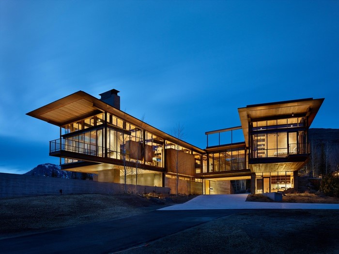 Modern luxury mansion with glass walls at dusk