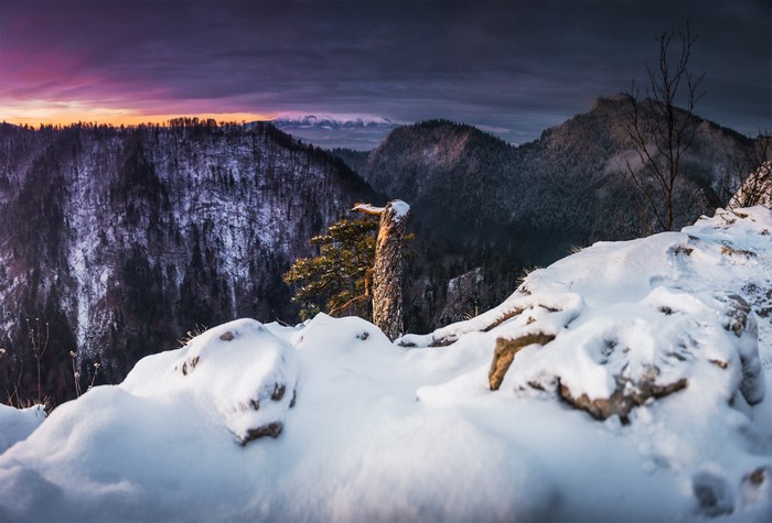 Snowy mountains at sunset with purple and orange sky