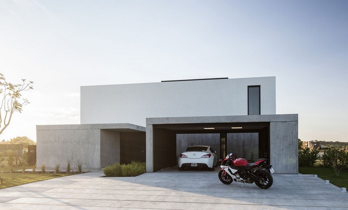 Modern concrete house with cars and motorcycle
