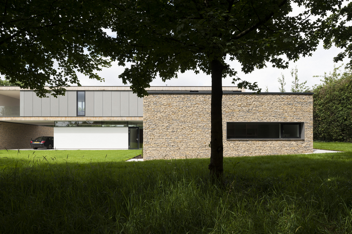 Modern house with stone facade and car in garage