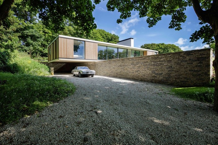 Modern house with stone wall and classic car