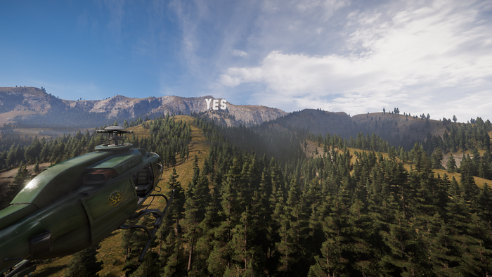 Helicopter flying towards YES sign on a mountain in Far Cry 5