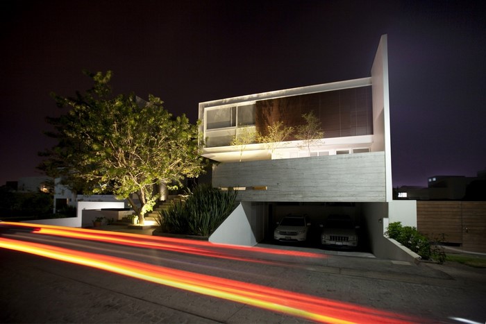 Modern concrete and white house at night with light trails