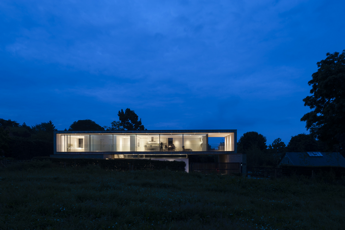 Modern luxury house with glass walls at dusk