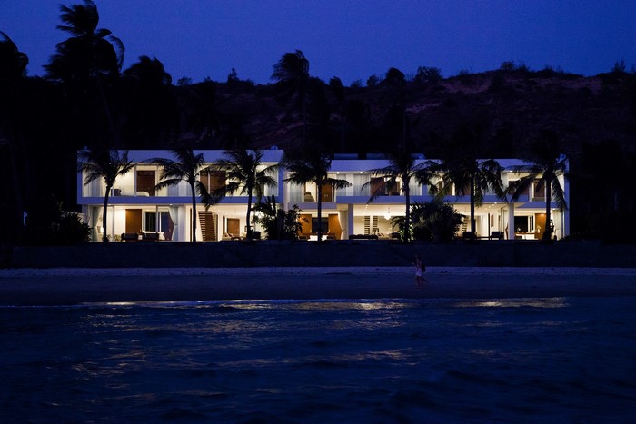 Modern luxury houses with palm trees at night