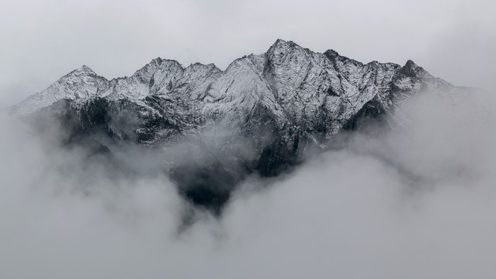 Snow-capped mountains shrouded in clouds