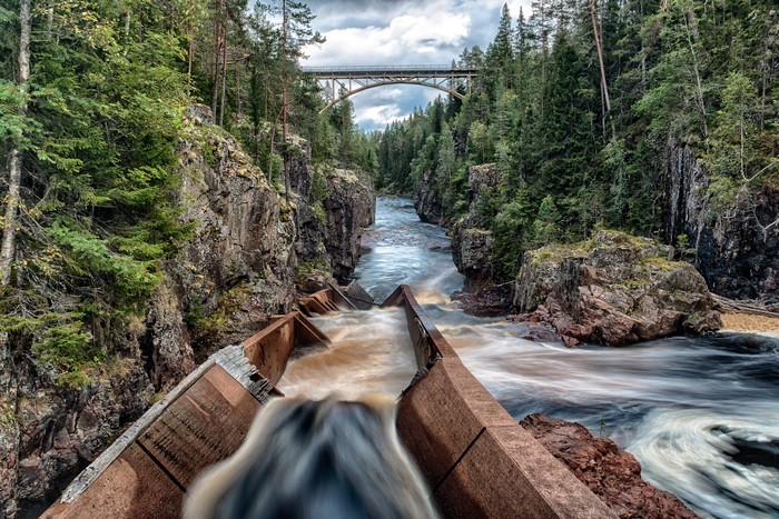 River flowing through a gorge with a bridge overhead