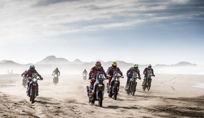 Motorcyclists racing on a sandy terrain during a rally