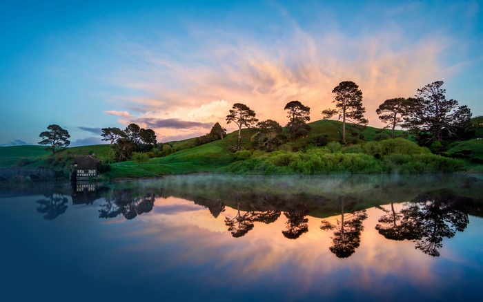 Hobbiton landscape with lake and cottage at sunrise