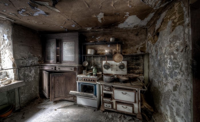 Abandoned kitchen with old stove and cabinets