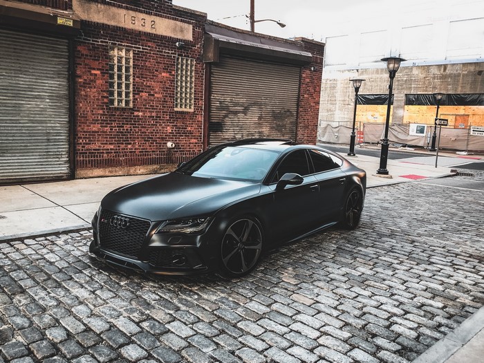 Black Audi Coupe on Urban Cobblestone Street