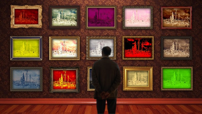Man looking at colorful paintings in a gallery