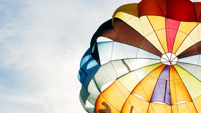 Colorful parachute against a bright sky