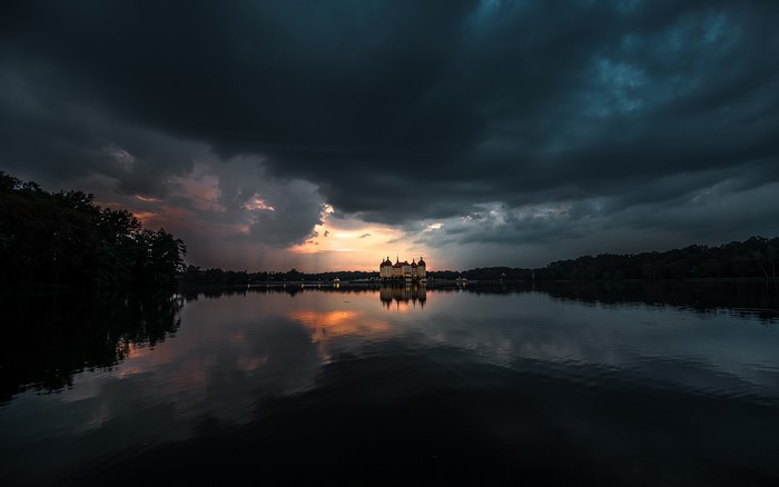 Moritzburg Castle reflected in a lake under dark clouds