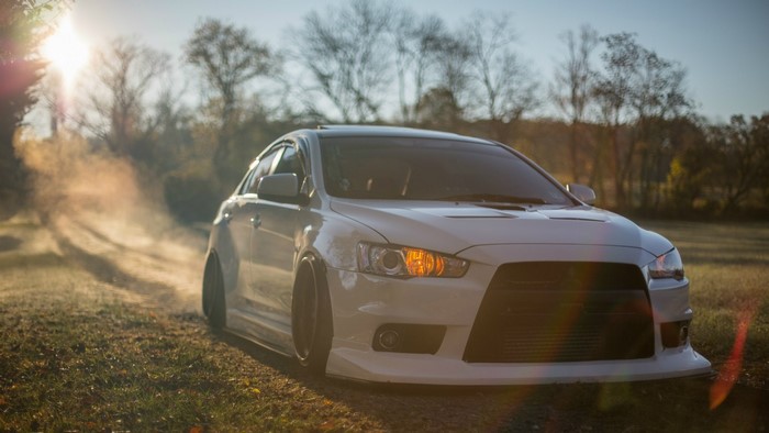 White Mitsubishi Lancer EVO on a dirt road