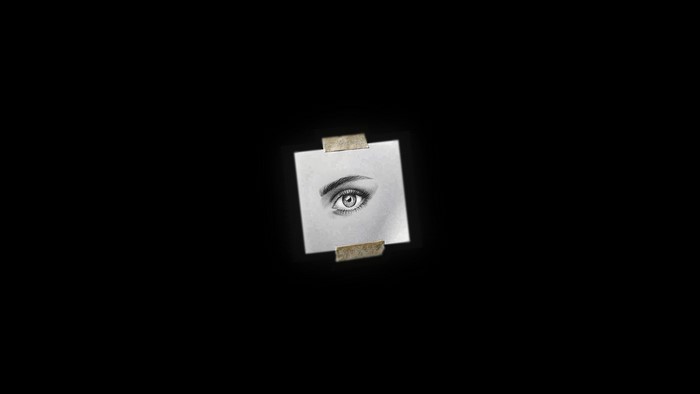 Pencil sketch of an eye taped to a black background