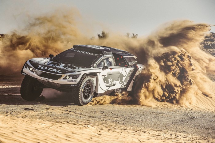 Peugeot rally car kicking up sand