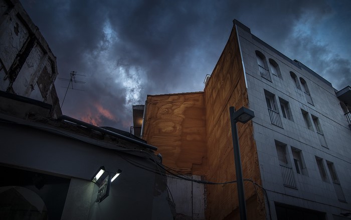 Urban buildings at dusk with dark clouds