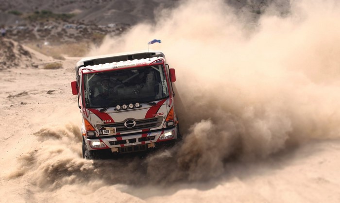 Hino racing truck kicking up dust on a sandy track