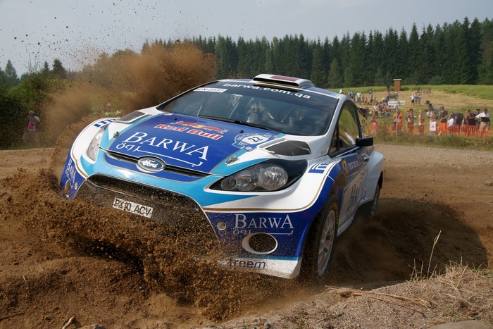 Ford Fiesta WRC rally car driving through dirt
