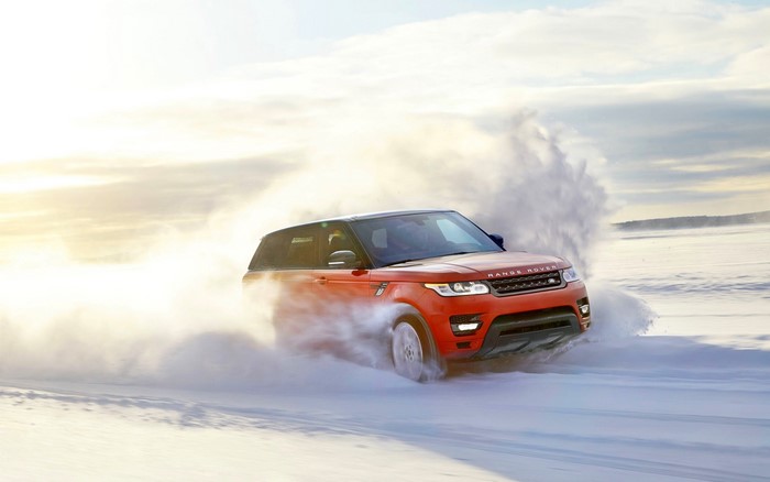 Red Range Rover driving through snow