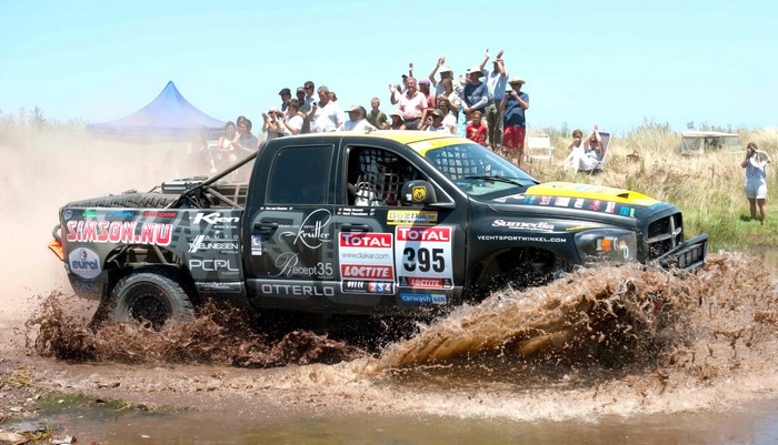 Dakar Rally truck with number 395 driving through mud