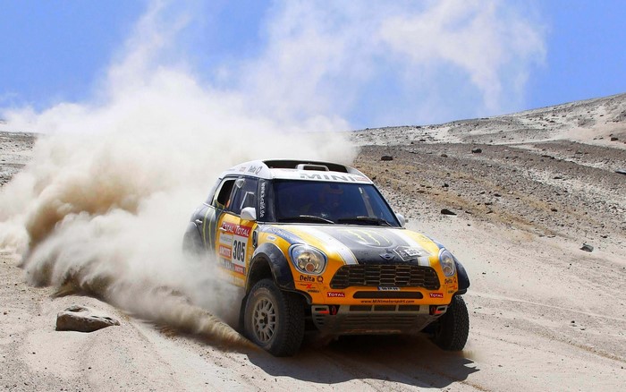 Mini Cooper rally car racing through dust
