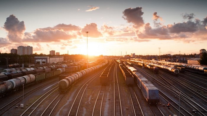Sunset over a busy rail yard with many trains