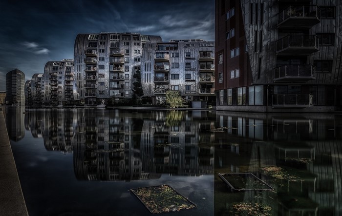 Modern buildings reflected in dark water in the Netherlands