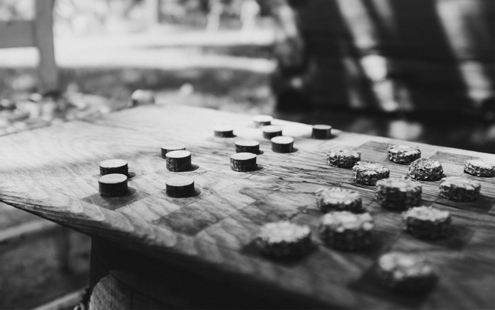 Monochrome photography of a checkerboard with wooden pieces