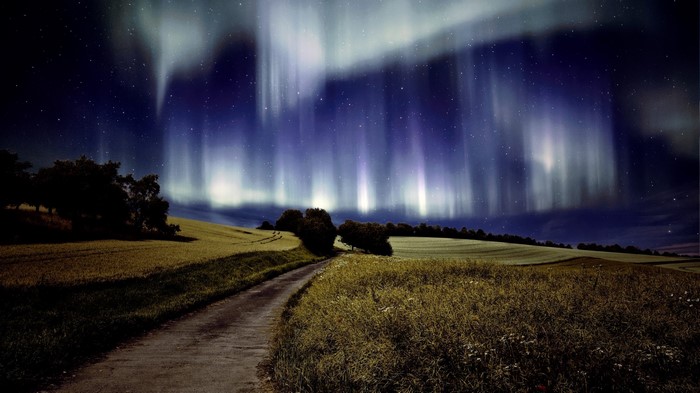 Aurora Borealis over a rural landscape at night