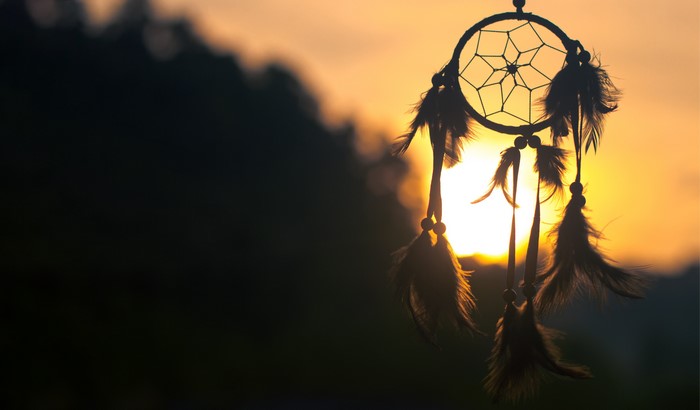 Dreamcatcher silhouetted against sunset