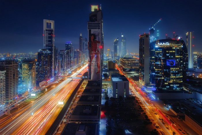 Dubai cityscape at night with light trails on highway