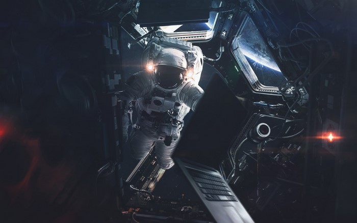 Astronaut in space with a laptop