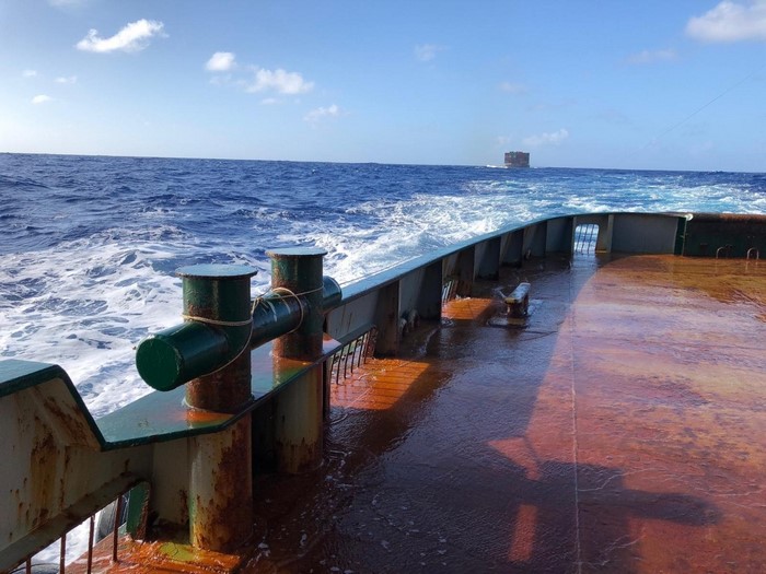 Ship deck with ocean and distant cargo ship