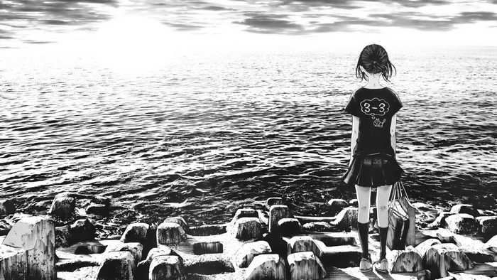 Girl on a rocky shore looking at the sea