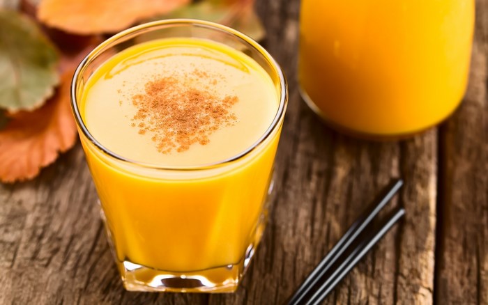 Orange juice with cinnamon on a wooden table