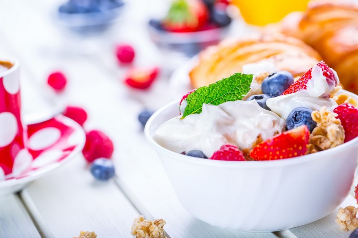 Healthy breakfast with yogurt, berries, and croissants