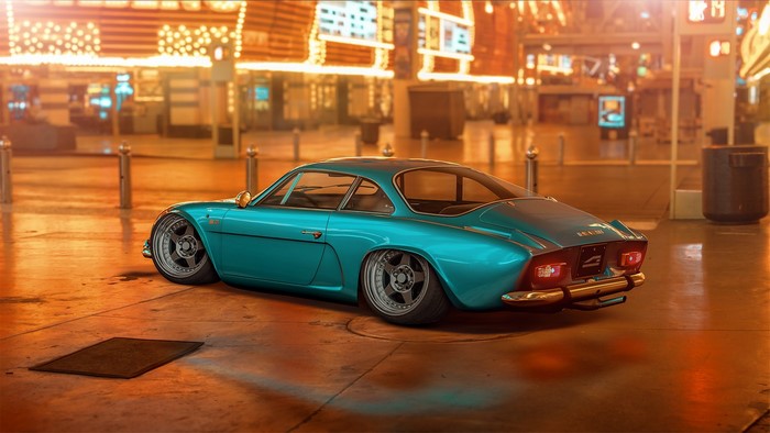 Stanced turquoise Alpine A110 in a city at night