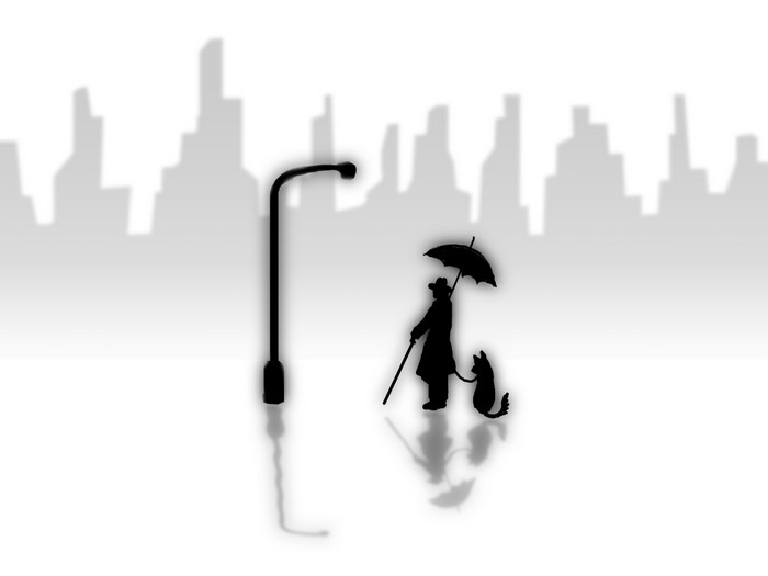Silhouette of a person with a dog and umbrella under a street light