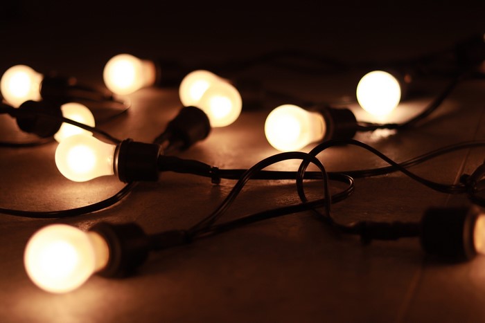 String of glowing light bulbs on a dark surface