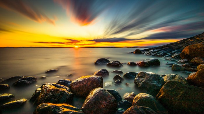 4K stones and clouds at sunset over the sea
