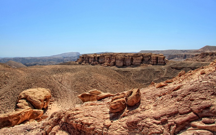 Desert landscape with rock formations and clear blue sky