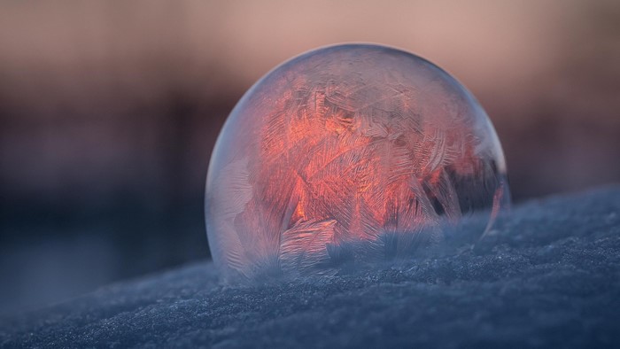 Frozen bubble with ice patterns at sunset