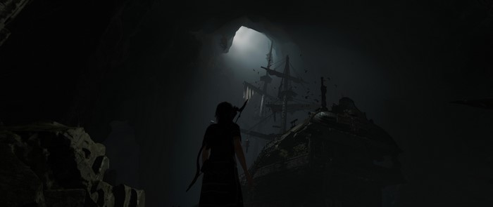 Lara Croft from Shadow of the Tomb Raider in a cave with a ship