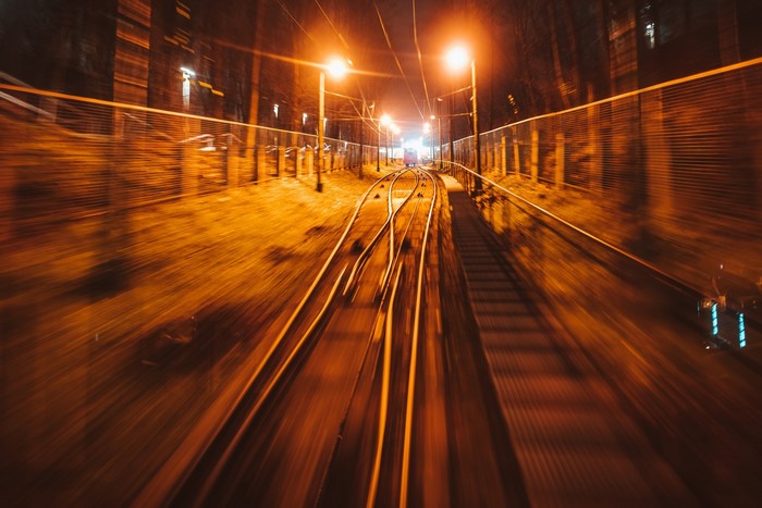 Train tracks at night with streetlights