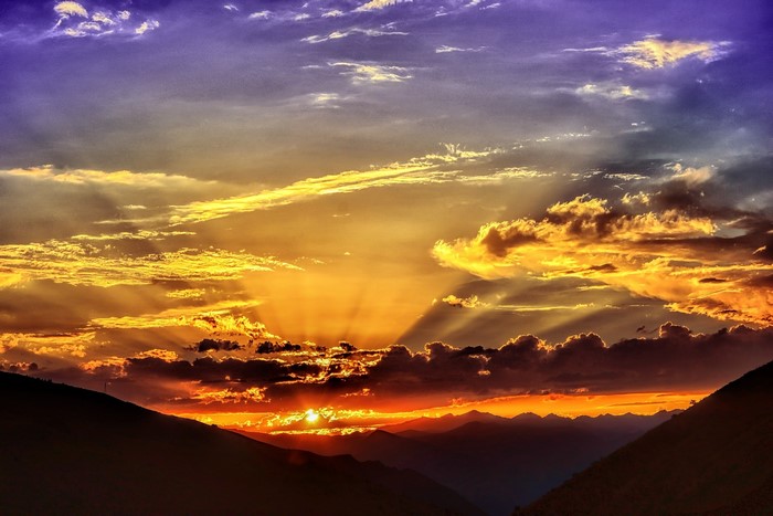 Dramatic sunset over mountains with sun rays