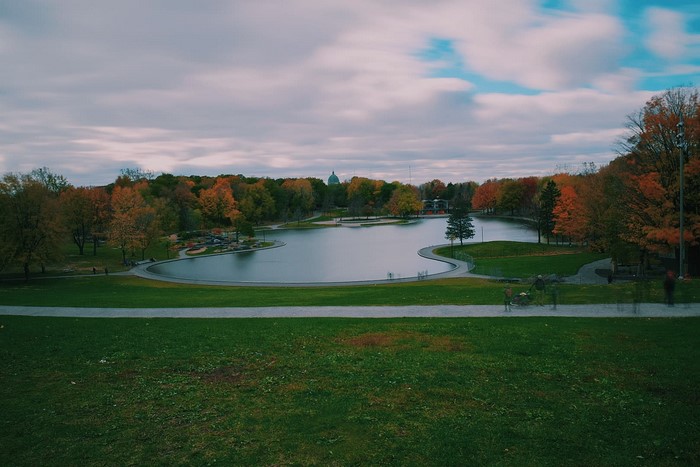 Park pond with autumn trees and a dome building