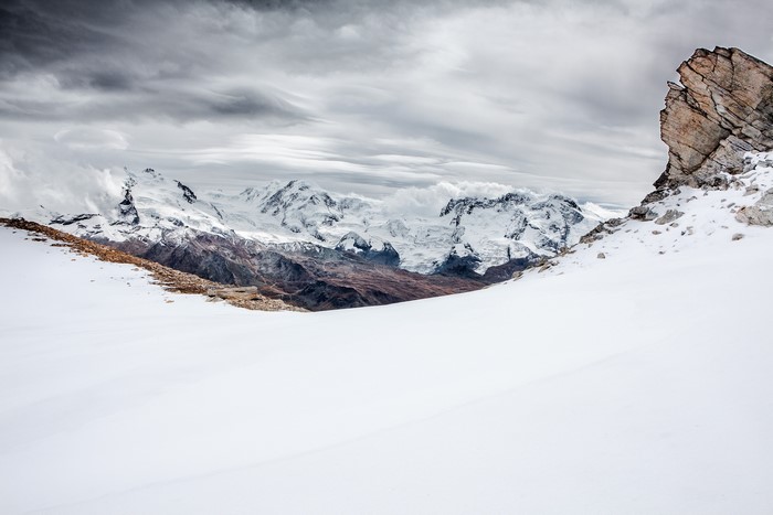 Snow-covered mountains under a cloudy sky