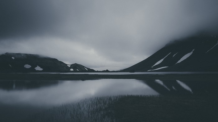 Gloomy mountain landscape with lake and overcast sky